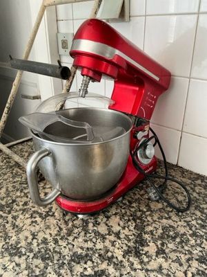 a red mixer sitting on a counter in a kitchen