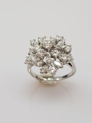 a close up of a diamond ring on a white surface