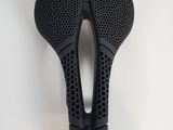 the bike seat is made of black plastic and has holes on it