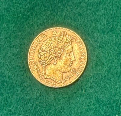 une pièce d'or posée sur une surface verte