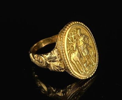 a close up of a gold ring on a black surface