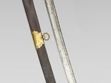 a close up of a sword with a wooden handle on a gray surface