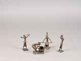 quatre figurines représentant des personnes assises sur une surface blanche