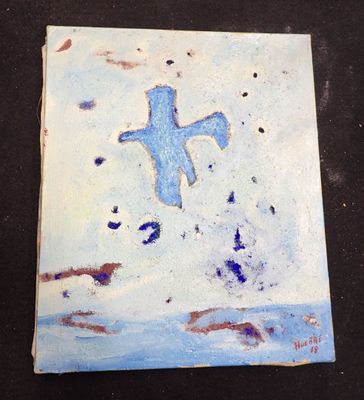 une peinture représentant une croix sur un carreau posé sur une table