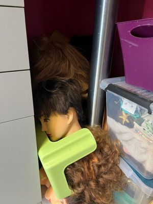 a doll with a hair brush and a hairbrush in a closet