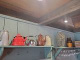 a shelf that has many different types of teapots on it