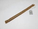 a gold chain bracelet with a tag on it