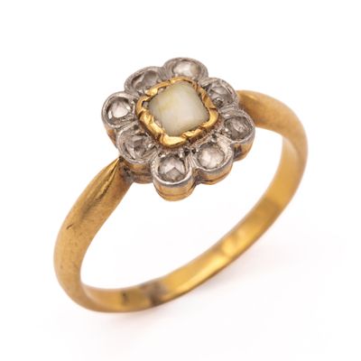 un gros plan d'une bague en or ornée d'une pierre blanche au centre