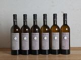 six bouteilles de vin sont alignées sur une table en bois