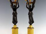 pair of antique bronze figurines of women holding baskets on pedestals