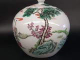 a white vase with a painting on it sitting on a table