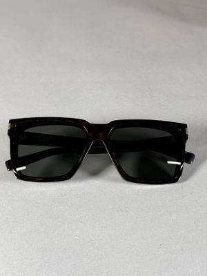 des lunettes de soleil noires posées sur une surface blanche, sur fond blanc