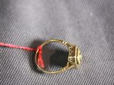 a gold ring with a red string around it