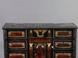 a black and gold chest of drawers with a clock on top