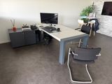 un bureau avec un ordinateur et une chaise dans une pièce