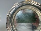 a silver plate with a clock on it next to a mirror