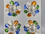 trois fleurs en verre multicolores posées sur une surface transparente avec un fond blanc