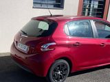 une voiture rouge garée devant un bâtiment