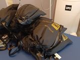 a pile of backpacks sitting on top of a blue table