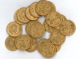 une pile de pièces d'or posée sur une surface blanche