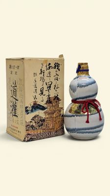 a small bottle with a design on it next to a box