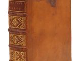 un livre en cuir marron avec des bordures dorées sur la couverture