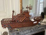 a wooden model of a boat sitting on top of a mantle