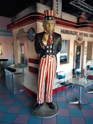 a statue of a man that is standing in front of a restaurant