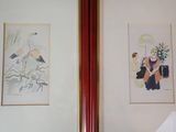 two framed pictures of birds on the wall above a bed