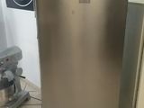 a stainless steel refrigerator in a kitchen with tile flooring