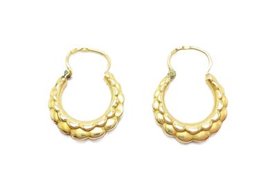 une paire de boucles d'oreilles créoles en or sur fond blanc