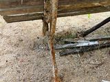 a wooden bench that has rust on the side of it