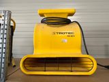 a close up of a yellow blower sitting on top of a cardboard box