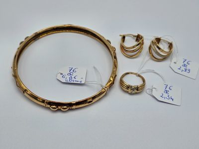 un ensemble de bagues et de boucles d'oreilles en or sur un fond blanc