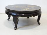 a small black table with a gold design on it