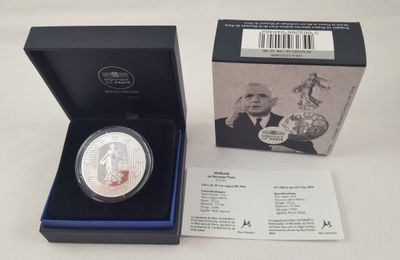 une pièce d'argent représentant un homme en costume-cravate, dans un coffret
