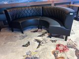 a black leather corner sofa with a butterfly rug on the floor