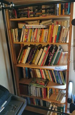 une bibliothèque remplie de livres dans une petite pièce