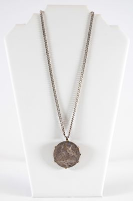 a close up of a necklace on a mannequin with a chain