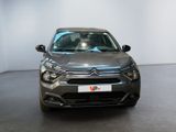 the front of a grey car is parked in a white room