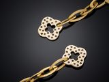a pair of gold plated heart shaped key chains on a black background