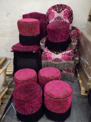 une pile de chaises et de tabourets roses et noirs