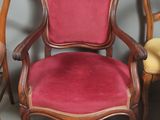 trois chaises en bois avec des assises recouvertes de velours rouge et une petite table