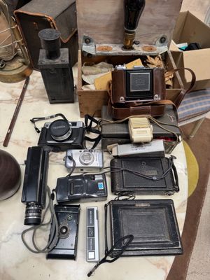 a lot of old cameras and other items on a table