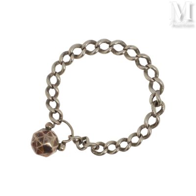 un gros plan d'un bracelet avec une boule suspendue à une chaîne