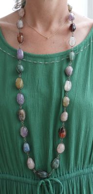 une femme portant une robe verte et un collier composé de perles multicolores