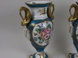 two blue vases with gold handles on each of them