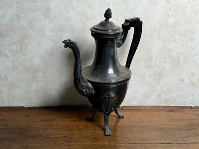 une théière en argent posée sur une table en bois