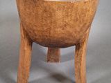 an old wooden bowl sitting on top of a wooden stand