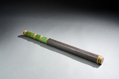 une image représentant un stylo vert et noir posé sur une table